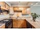 A kitchen with wood cabinets, black appliances, and a stainless steel sink, offering a functional cooking space at 1850 Folsom St # 402, Boulder, CO 80302