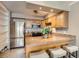 Efficient kitchen with stainless steel appliances, wooden cabinetry, and countertop with bar seating at 1850 Folsom St # 402, Boulder, CO 80302