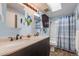 Bathroom with dual sinks, dark cabinets, and shower at 2022 S Helena St # G, Aurora, CO 80013