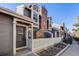 Inviting home exterior showcasing a brick chimney, fenced yard, and well-maintained facade on a sunny day at 2022 S Helena St # G, Aurora, CO 80013