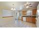Well-lit kitchen with tile flooring, wooden cabinets, modern appliances, and a view into the dining area at 14453 W 3Rd Ave, Golden, CO 80401