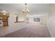 Bright living room with neutral walls and carpeting, a large window, and a partial view of the adjacent kitchen at 14453 W 3Rd Ave, Golden, CO 80401