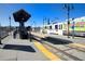 Daytime view of the light rail train and station, with pedestrian access and a covered shelter at 14453 W 3Rd Ave, Golden, CO 80401