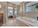 Bright bathroom featuring a soaking tub under a window and a separate glass-enclosed shower at 4883 S Sicily St, Aurora, CO 80015