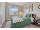 Cozy bedroom with a queen bed, large window overlooking the neighborhood, and a soft grey rug at 4883 S Sicily St, Aurora, CO 80015