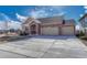 Lovely ranch-style home boasts a brick and tan exterior, plus a spacious three-car driveway at 4883 S Sicily St, Aurora, CO 80015