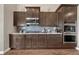 Modern kitchen featuring stainless steel appliances, wood cabinets, and sleek gray backsplash at 4883 S Sicily St, Aurora, CO 80015