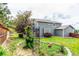 View of the backyard with grass and a two-story home with green siding at 21396 E Prentice Ln, Centennial, CO 80015