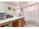 Bright bathroom featuring a large mirror, vanity, and shower with floral curtain at 21396 E Prentice Ln, Centennial, CO 80015