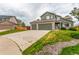 Two-story home boasts a three-car garage, green siding and a stone-accented facade, all under a cloudy sky at 21396 E Prentice Ln, Centennial, CO 80015