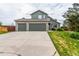 Charming two-story home showcases a three-car garage, green siding, and stone accents, set on a lush lawn at 21396 E Prentice Ln, Centennial, CO 80015