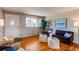 Living room with hardwood floors, a black sofa, and white ottomans at 867 S Everett St, Lakewood, CO 80226