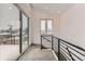 Open hallway with high ceilings featuring a balcony that has railings overlooking the snow covered neighborhood at 1433 Xavier St, Denver, CO 80204