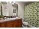 Bathroom with wood cabinets, neutral countertops, patterned shower curtain, and modern fixtures at 5421 Potentilla Ct, Parker, CO 80134