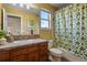 Bathroom with a large mirror, wood cabinets, and a shower-tub combo with a decorative curtain at 5421 Potentilla Ct, Parker, CO 80134