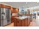 Spacious kitchen with wood cabinets, a large center island cooktop, and stainless steel appliances at 5421 Potentilla Ct, Parker, CO 80134