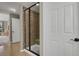 A tiled shower featuring a glass door, bench, and neutral tones at 5421 Potentilla Ct, Parker, CO 80134