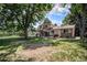 Large backyard with mature trees, a patio area, and a well-maintained lawn at 8727 E Girard Ave, Denver, CO 80231