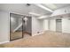Finished basement with carpeting, sliding glass doors, and access to storage and other areas of the home at 8727 E Girard Ave, Denver, CO 80231