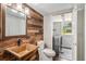 Stylish bathroom with rustic wood accent wall, vessel sink, modern fixtures, and a washer-dryer room access at 8727 E Girard Ave, Denver, CO 80231