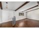 Bright living room featuring hardwood floors, wood beam ceiling accents, and a large window providing natural light at 8727 E Girard Ave, Denver, CO 80231
