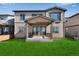 Spacious backyard featuring a covered patio, a well-maintained lawn, and a sliding glass door entrance at 13398 E 99Th Pl, Commerce City, CO 80022