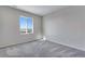Bright bedroom features a large window, plush carpet, and neutral paint, creating a serene and comfortable space at 13398 E 99Th Pl, Commerce City, CO 80022