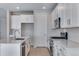 Modern kitchen with white cabinets, stainless steel appliances, and quartz countertops at 13398 E 99Th Pl, Commerce City, CO 80022