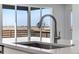 Close-up of a kitchen island featuring a sink, modern faucet, and bright natural light at 13398 E 99Th Pl, Commerce City, CO 80022