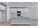 Bright kitchen boasts modern white cabinets, an island with sink, and stainless appliances at 13398 E 99Th Pl, Commerce City, CO 80022