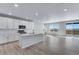 Open concept kitchen features white cabinets, a center island, and views of the outdoors at 13398 E 99Th Pl, Commerce City, CO 80022