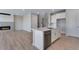 Open-concept kitchen with a quartz countertop island, stainless steel appliances, and wood floors at 13398 E 99Th Pl, Commerce City, CO 80022