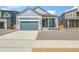Charming single-story home with blue siding, stone accents, a gray garage door, and a well-maintained front yard at 9343 Biscay St, Commerce City, CO 80022