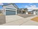 Attractive single-story home featuring a blue garage door and siding, stone accents, and a concrete driveway at 9343 Biscay St, Commerce City, CO 80022