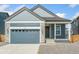 Inviting home exterior with a gray garage door and stone siding accents at 9343 Biscay St, Commerce City, CO 80022