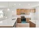 Well-equipped kitchen boasts stainless steel appliances, custom wood cabinets, and white stone countertops at 9343 Biscay St, Commerce City, CO 80022
