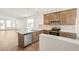 Open kitchen featuring stainless steel appliances, wood cabinets, and a center island with white stone countertops at 9343 Biscay St, Commerce City, CO 80022