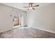 Bedroom boasts neutral walls, gray wood-look flooring, ceiling fan, and sliding glass door at 8915 Field St # 118, Broomfield, CO 80021
