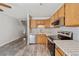 Bright kitchen features stainless steel appliances, wooden cabinets, modern countertops, and gray wood-look flooring at 8915 Field St # 118, Broomfield, CO 80021