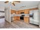 Bright kitchen featuring stainless steel appliances, wooden cabinets, modern countertops, and gray wood-look flooring at 8915 Field St # 118, Broomfield, CO 80021