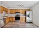 Bright kitchen features stainless steel appliances, wooden cabinets, modern countertops, and gray wood-look flooring at 8915 Field St # 118, Broomfield, CO 80021
