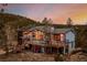 Stunning exterior view of home with deck, solar panels and beautiful wooded surroundings at 37 High View Ln, Boulder, CO 80302