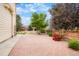 Brick patio surrounded by landscaping features a low fence offering privacy and curb appeal at 16650 E 107Th Ct, Commerce City, CO 80022