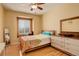 Cozy bedroom with a playful bedspread, window seat, dresser, mirror, and hardwood floors at 16650 E 107Th Ct, Commerce City, CO 80022