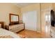 Comfortable bedroom with hardwood floors, a sliding door closet, and a light-colored dresser with mirror at 16650 E 107Th Ct, Commerce City, CO 80022
