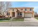 Charming two-story home with manicured lawn, arched entrance, and a two car attached garage at 16650 E 107Th Ct, Commerce City, CO 80022