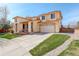 Exterior view showcasing a spacious driveway, attached two-car garage, and a well-maintained lawn at 16650 E 107Th Ct, Commerce City, CO 80022