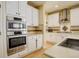 Bright kitchen featuring stainless steel appliances, double ovens, and white cabinets at 16650 E 107Th Ct, Commerce City, CO 80022