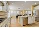Open kitchen with white cabinets, stainless steel appliances, and an island with seating at 16650 E 107Th Ct, Commerce City, CO 80022