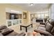 Open-concept living room with a fireplace, built-in shelving, and seamless transition to the kitchen at 16650 E 107Th Ct, Commerce City, CO 80022